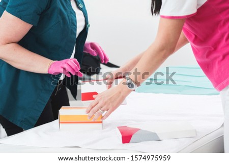Closeup image of preparing. Cropped picture of female hands they open up accessories for cosmetic medical treatment at the medical office table