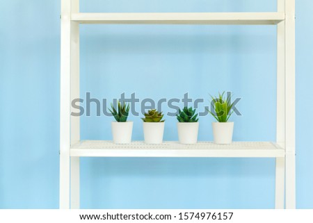 White metal rack with books against blue background