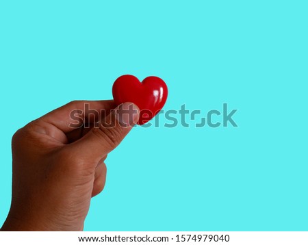 Gift red heart hold in hand. Royalty high-quality free stock images of hands holding gift red heart, health care, valentine, love and family concept, world heart day isolated on green background
