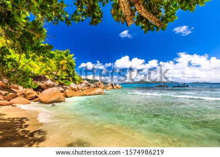 Felicite Island in Indian Ocean, Seychelles close to La Digue. Palm trees, snorkeling paradise, turquoise sea and boulder granite stone on white beach. Tropical nature background. Royalty-Free Stock Photo #1574986219