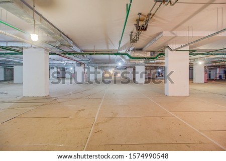 Underground parking in construction phase. Empty garage in basement of office building under construction. Parking without cars. Reinforced concrete monolithic walls in basement of house before repair