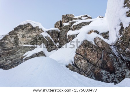 Frozen rocks. Rock hill with heavy snow. Beautiful contrast between snow and rocks.  Royalty-Free Stock Photo #1575000499