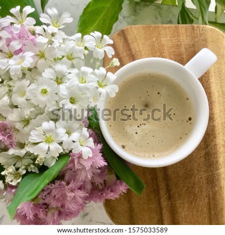 Morning Cup of coffee and a beautiful flowers on wooden background, top view. Cozy Breakfast. Flat lay style.