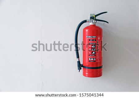 a fire extinguisher on the wall Royalty-Free Stock Photo #1575041344
