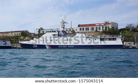 Russian Coast Guard ship in Sevastopol, Republic of Crimea, Russia. Translation of the inscription on board - "Coast Guard" Royalty-Free Stock Photo #1575043114
