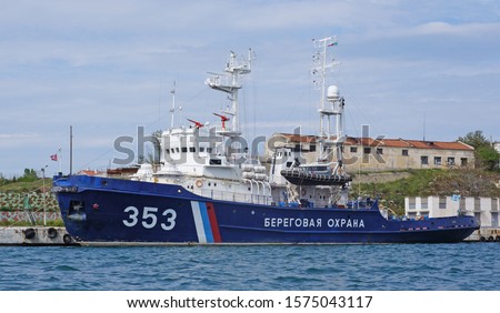 Russian Coast Guard ship in Sevastopol, Republic of Crimea, Russia. Translation of the inscription on board - "Coast Guard" Royalty-Free Stock Photo #1575043117