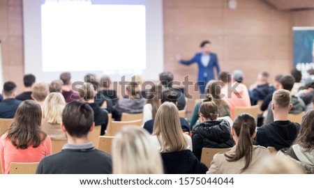 Speaker giving a talk in conference hall at business event. Audience at the conference hall. Business and Entrepreneurship concept. Focus on unrecognizable people in audience. Royalty-Free Stock Photo #1575044044