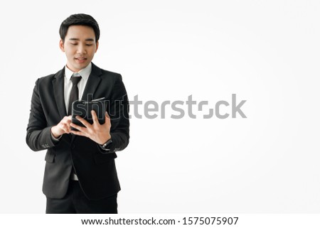 Young asian  businessman in black suit standing  and using a tablet computer  isolated over a white background,Intelligent and confident people, Successful leader.