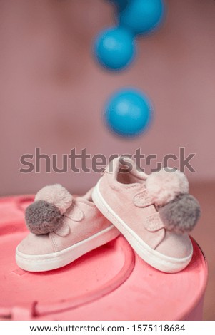 
Little baby pink shoes on a pink background.