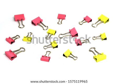 Scattered paper clips isolated white background - pink yellow pastel color 