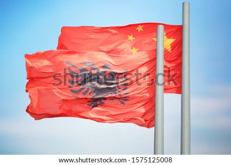 Albanian and Chinese flags amid blue skies