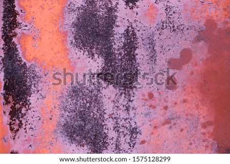 Background. Old and worn colored metal wall. In pink shades and dark spots.