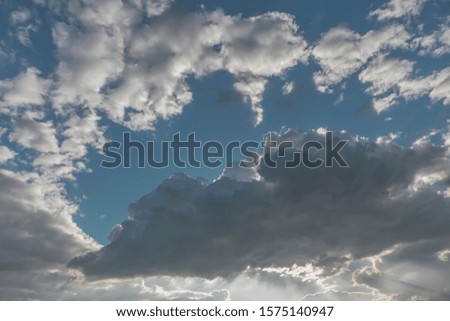Clouds covered the daytime sky in bright sunlight.