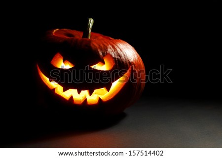Halloween pumpkin with scary face on black background Royalty-Free Stock Photo #157514402