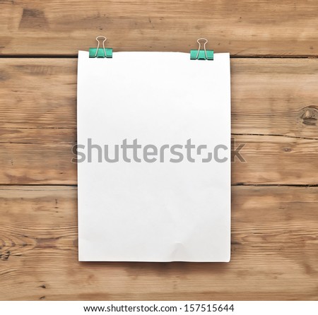 white blank note paper and paper clip on wood background