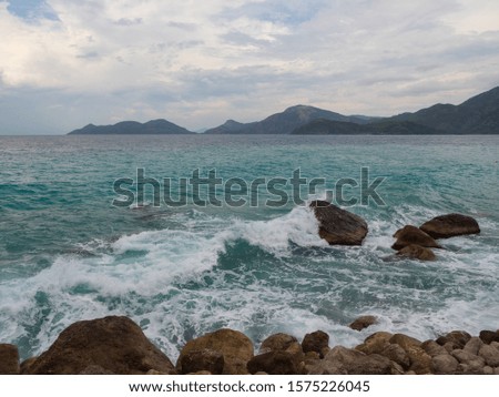 Sea and waves on a cloudy day. Rocky shore.