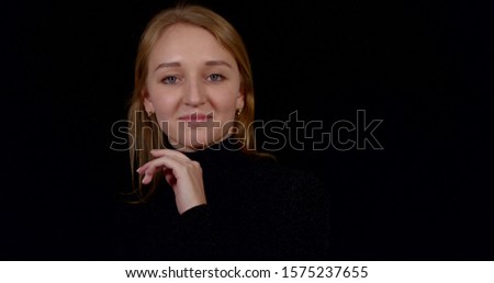 happy girl in black clothes talks posing on dark background