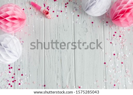 Wooden background with paper decorations for a party. Frame for greeting card, invitation to a party, wedding. View from above