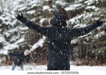 Young Happy friends enjoying throwing Snow balls, Having Fun in a Snowy Mountain .