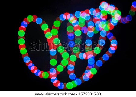Bokeh effect on round red, green and blue lights. Abstract blurred leds garland for background.