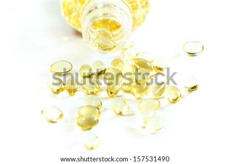 Omega 3 fish oil capsules out open container on white background