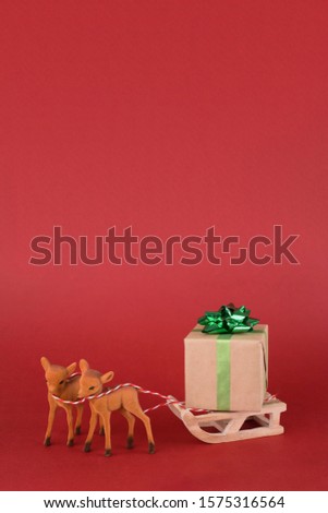Christmas or New year background design. Reindeer with winter sleigh and gift box on red background. Christmas background with space for text.