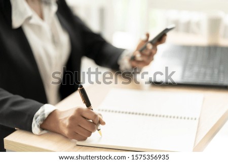 Close up of Hand African American Business Woman Use Phone in Office Place. She uses her Mobile phone to Search, Check, and Record her Work.