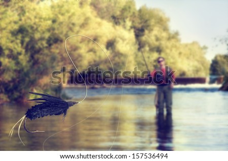 a person fly fishing in a river with a fly in the foreground Royalty-Free Stock Photo #157536494