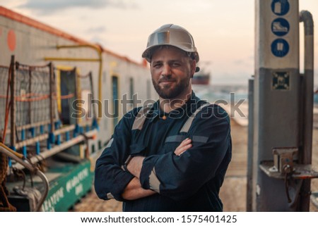 Marine Deck Officer or Chief mate on deck of offshore vessel or ship , wearing PPE personal protective equipment - helmet, coverall Royalty-Free Stock Photo #1575401425