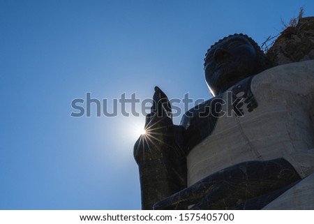 Buddha Bless on blue sky in the sun, Buddha statue standing under the sunrise with sky background