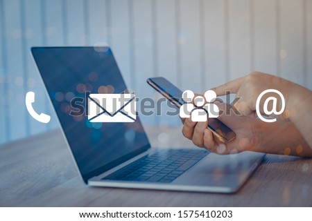 Contact us or Customer support hotline people connect. Businessman using a laptop with the (email, call phone, mail) icons. Royalty-Free Stock Photo #1575410203