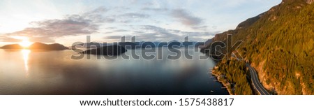 Sea to Sky Hwy in Howe Sound near Horseshoe Bay, West Vancouver, British Columbia, Canada. Aerial panoramic view during a colorful sunset in Fall Season. Royalty-Free Stock Photo #1575438817