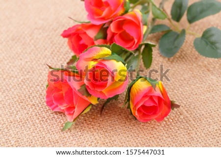 Colorful fabric roses on canvas background, closeup picture.