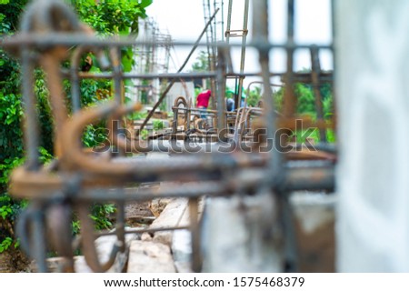 Selective focus on the reinforcement steel for concrete structure with blurred workers in background at construction site