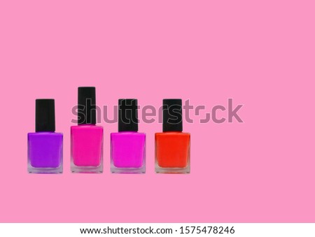 Nail polish bottles on pink background.  Various colors. Mockup for elegant design with copy space. 