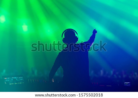 Charismatic disc jockey. Club, disco DJ playing and mixing music for crowd people. Royalty-Free Stock Photo #1575502018