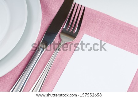 Shiny new cutlery, silverware and cardboard card close up on white background