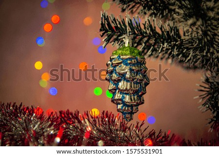 silver blue Christmas tree toy on a branch and colorful lights. New year and Christmas decorations