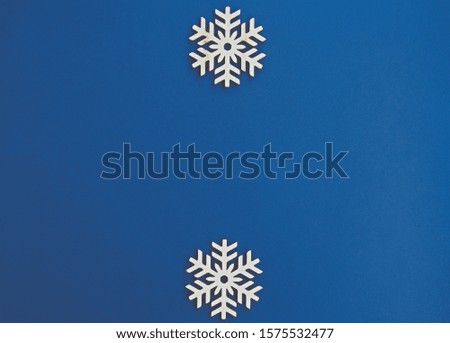 Blue winter holiday background.Flat lay wooden snowflakes on empty backdrop for Merry Christmas & Happy New Year wallpaper design.Place text on empty space for holidays poster