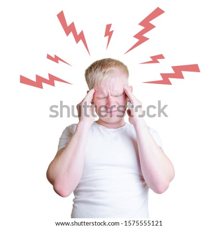 The concept of a headache, illness, feeling sick. A young Caucasian male blond holds his head in his hands. Above his head are painted lightning of red color. White background. Copy space.