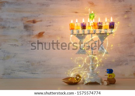 Religion image of jewish holiday Hanukkah background with david star menorah (traditional candelabra) and colorful oil candles