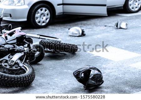 Helmet and motorcycle on the street after car crash Royalty-Free Stock Photo #1575580228