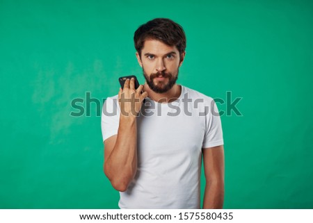 A man in a white T-shirt holds a smartphone in the hands of a technology service provider