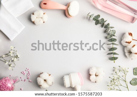 Flat lay composition with face cleansing brushes on light grey background. Cosmetic accessories