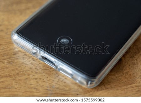 mobile phone on a wooden table - lock screen with fingerprint id 