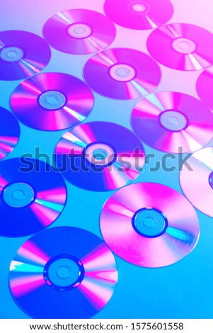 CDs on a plain background illuminated with neon light pink blue, Concept of night club life ,minimal style