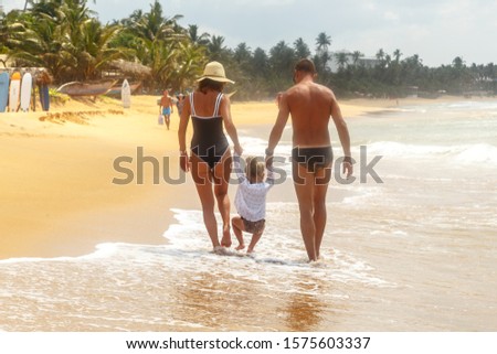 Mother and children go home from beach. Happy family resting on the sunset background. Sun kissed child