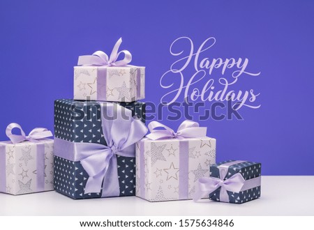  Lot of gift boxes on white background. Craft gifts and blue paper decorated with lilac satin ribbon bows. Christmas and other holidays concept.