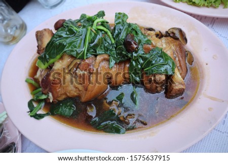 Pictured top view, Chinese pork stewed pork leg with herbs and kale in a Chinese food concept dish.