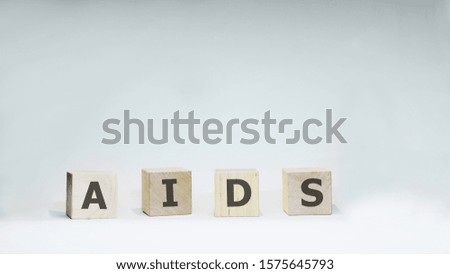 Word AIDS with wooden letters on white background.
